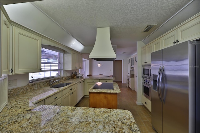 kitchen featuring kitchen peninsula, sink, stainless steel appliances, and cream cabinets