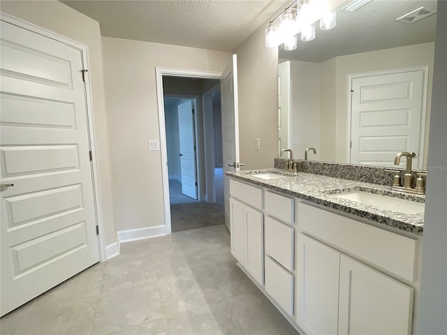 bathroom featuring a textured ceiling and vanity