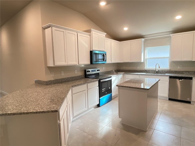 kitchen with lofted ceiling, dishwasher, a kitchen island, range with electric stovetop, and white cabinets