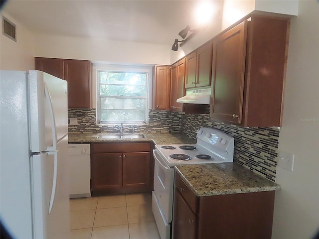 kitchen with tasteful backsplash, white appliances, light tile patterned flooring, light stone countertops, and sink