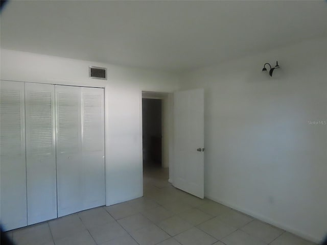 unfurnished bedroom featuring light tile patterned floors and a closet