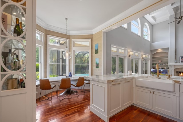 sunroom / solarium featuring ceiling fan, plenty of natural light, and sink