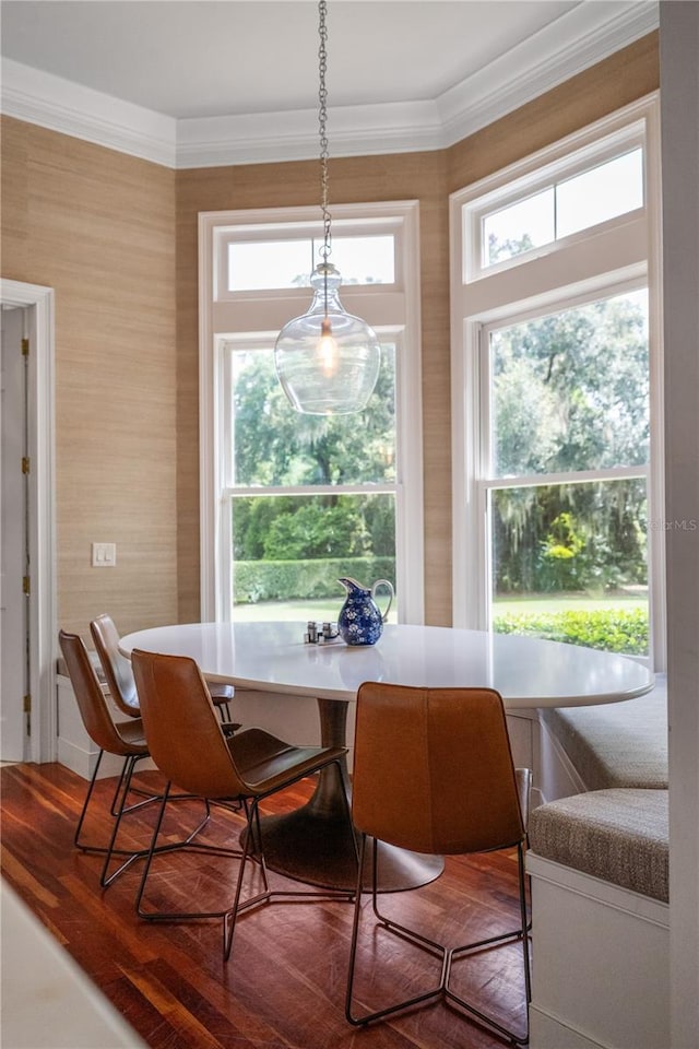 dining space featuring hardwood / wood-style flooring, crown molding, and breakfast area