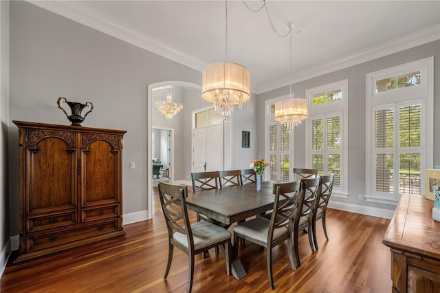 dining room with crown molding, dark hardwood / wood-style floors, and a notable chandelier