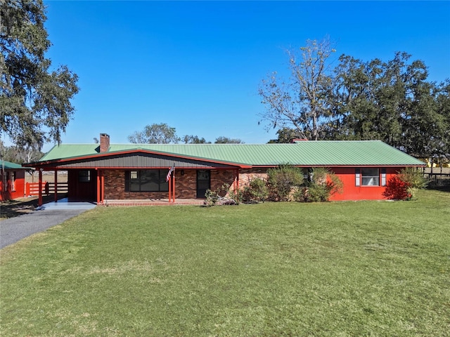 ranch-style home featuring a front lawn and a carport