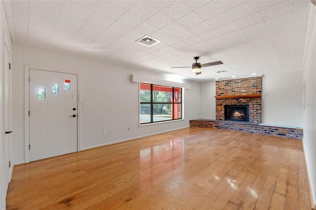 unfurnished living room with ceiling fan, light hardwood / wood-style floors, and a brick fireplace