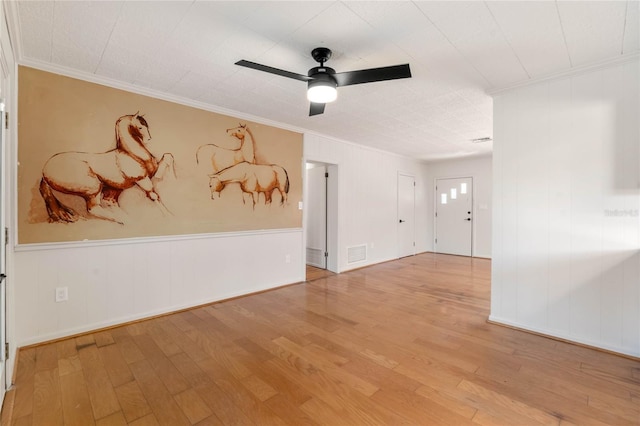 empty room featuring ceiling fan, ornamental molding, and light hardwood / wood-style flooring