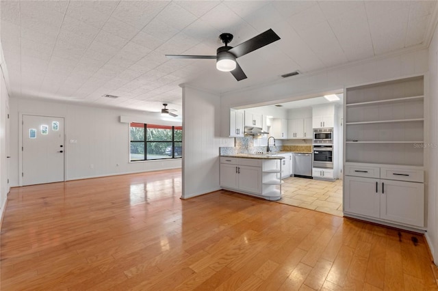 kitchen with sink, appliances with stainless steel finishes, ceiling fan, light hardwood / wood-style floors, and white cabinets