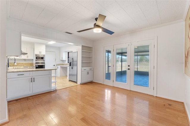 kitchen featuring white cabinetry, light hardwood / wood-style flooring, french doors, and appliances with stainless steel finishes