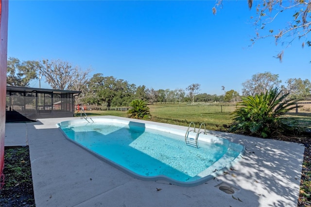 view of pool featuring a lawn, a sunroom, and a patio