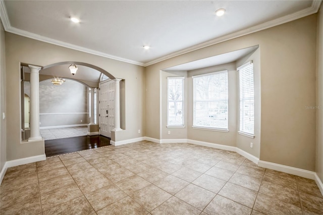 tiled spare room featuring crown molding and ornate columns