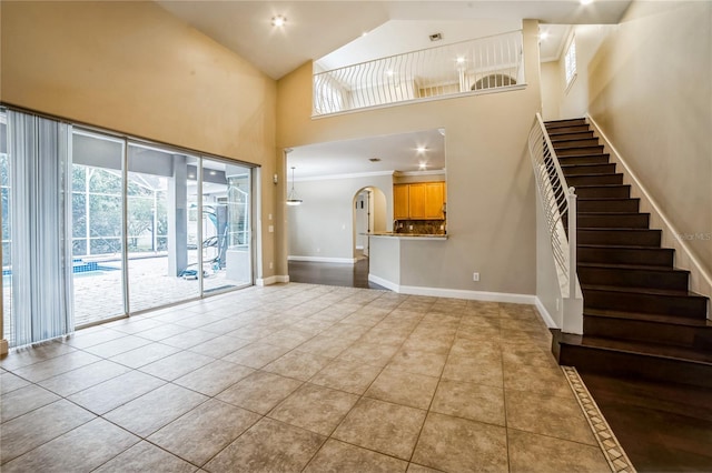 unfurnished living room with a high ceiling and light tile patterned floors