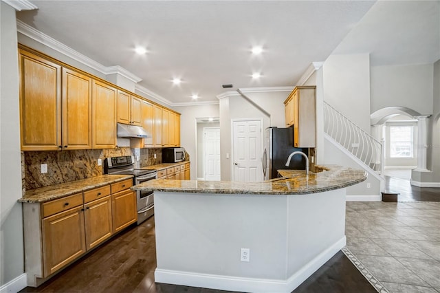 kitchen featuring sink, decorative backsplash, light stone countertops, and appliances with stainless steel finishes