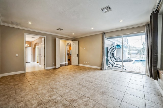 spare room with ornamental molding, light tile patterned floors, and a textured ceiling