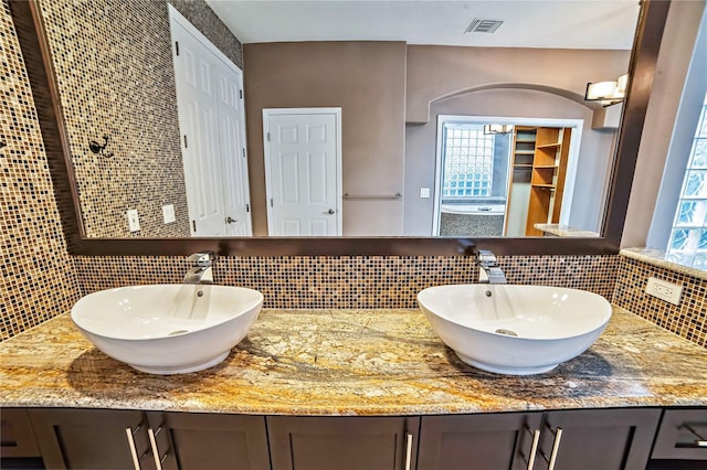 bathroom featuring decorative backsplash and vanity