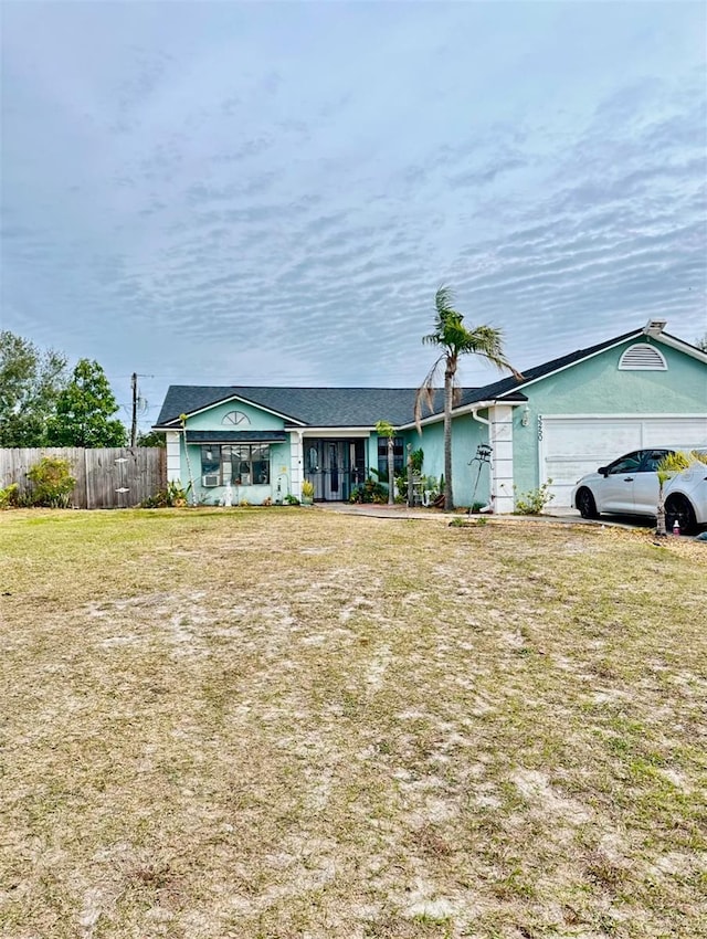 ranch-style home featuring a front lawn and a garage