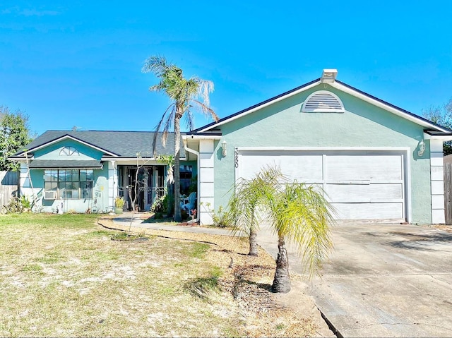 ranch-style house with a front lawn, concrete driveway, an attached garage, and stucco siding