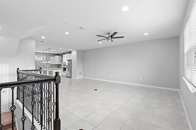 tiled spare room with ceiling fan