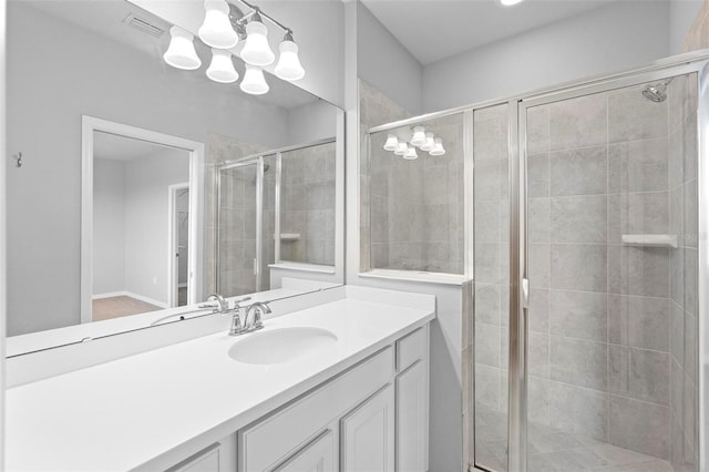 bathroom with a chandelier, an enclosed shower, and vanity