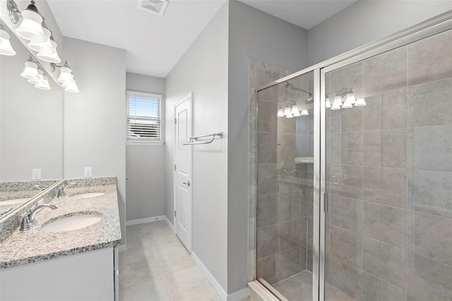 bathroom with an enclosed shower, vanity, and tile patterned flooring