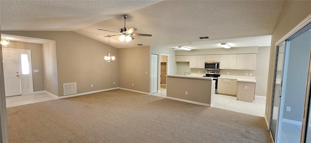 kitchen featuring vaulted ceiling, white cabinetry, stainless steel appliances, light carpet, and ceiling fan with notable chandelier