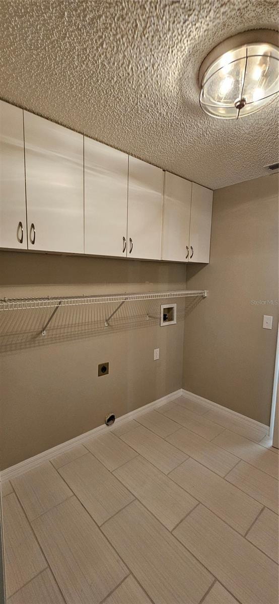 clothes washing area featuring cabinets, hookup for a washing machine, and electric dryer hookup