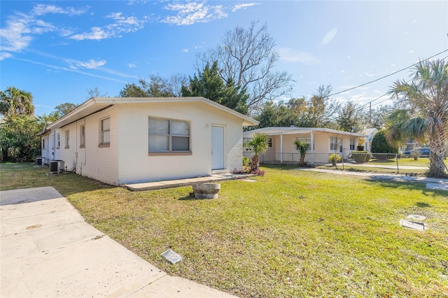 view of front of house featuring central AC and a front yard