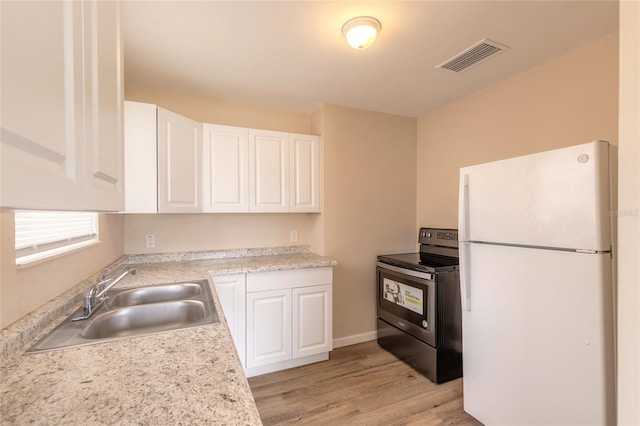 kitchen with sink, stainless steel electric range oven, white cabinets, and white fridge