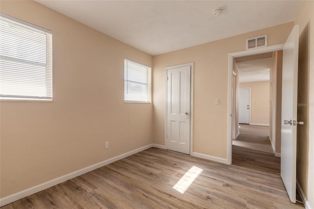 unfurnished bedroom featuring light hardwood / wood-style floors and a closet