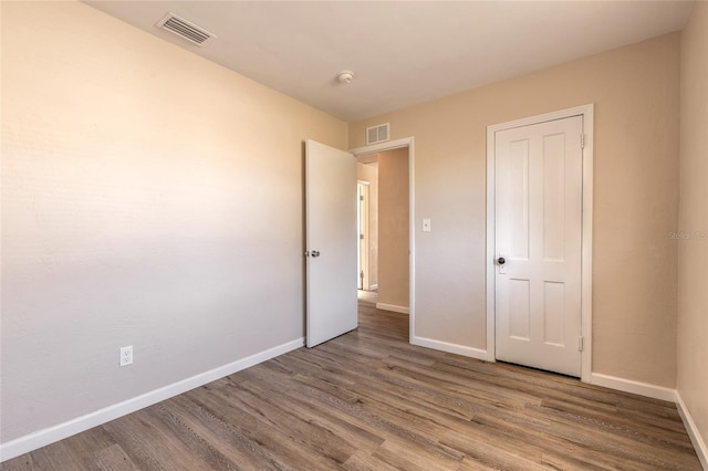 unfurnished bedroom with hardwood / wood-style floors and a closet