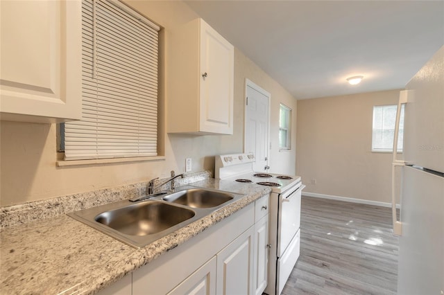 kitchen featuring light wood-type flooring, white appliances, sink, and white cabinets