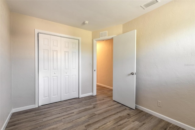 unfurnished bedroom featuring hardwood / wood-style flooring and a closet