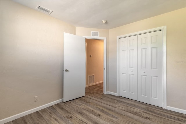 unfurnished bedroom featuring hardwood / wood-style flooring and a closet