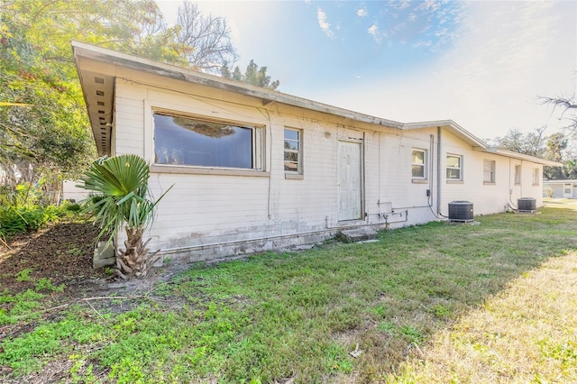 view of property exterior with central AC and a yard