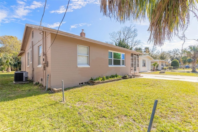 view of property exterior with a yard and central AC