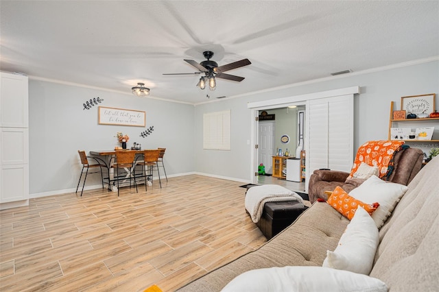 living room featuring crown molding and ceiling fan