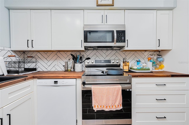 kitchen featuring stainless steel appliances, white cabinetry, wood counters, and decorative backsplash