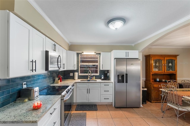 1309 Paradise Ln, Winter Park, FL 32792 - kitchen with white cabinetry, stainless steel appliances, sink, backsplash, and light tile patterned floors