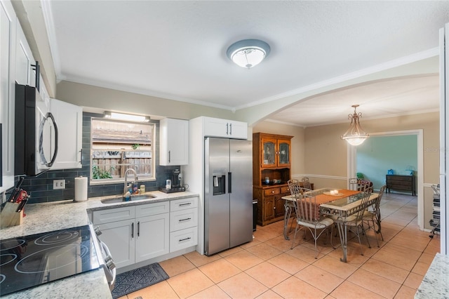 1309 Paradise Ln, Winter Park, FL 32792 - kitchen featuring hanging light fixtures, sink, white cabinetry, light tile patterned floors, and stainless steel appliances
