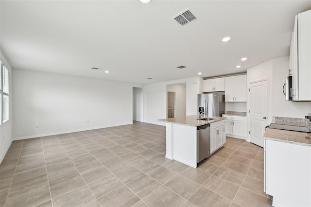 kitchen featuring visible vents, a center island with sink, light tile patterned floors, open floor plan, and stainless steel appliances