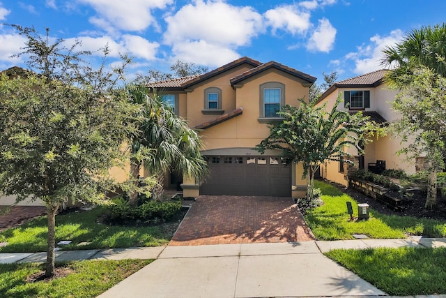 mediterranean / spanish house with a garage and a front yard