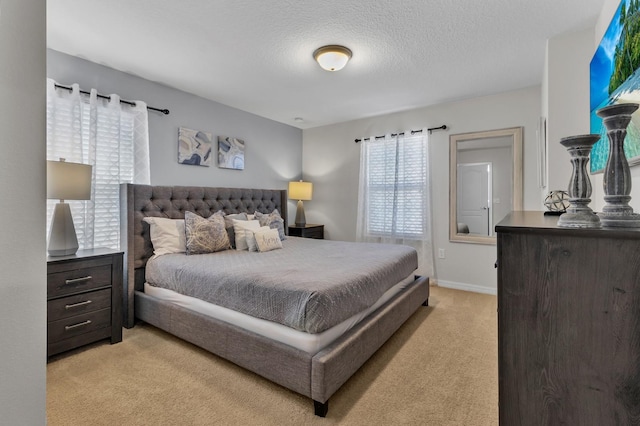 bedroom featuring light colored carpet and a textured ceiling