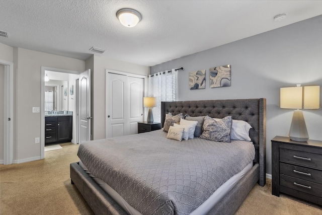 carpeted bedroom with a textured ceiling, a closet, and connected bathroom