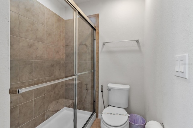 bathroom with an enclosed shower and toilet