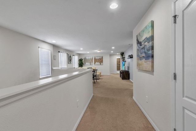 hall with light colored carpet