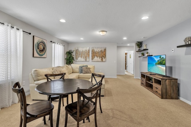 carpeted dining area with a textured ceiling