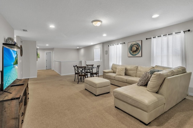 carpeted living room featuring a textured ceiling