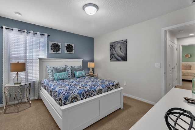 bedroom with carpet, multiple windows, and a textured ceiling