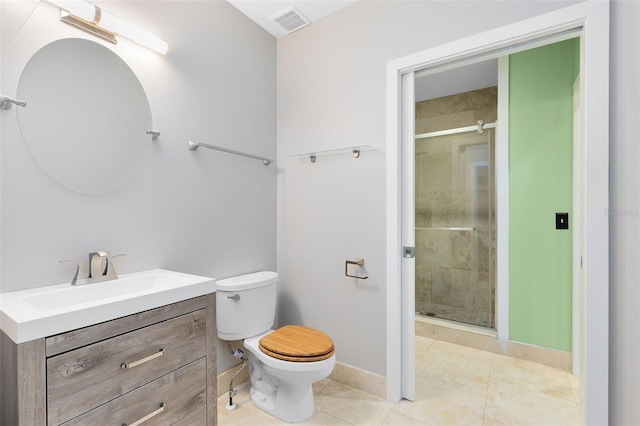 bathroom featuring tile patterned floors, a shower with door, toilet, and vanity