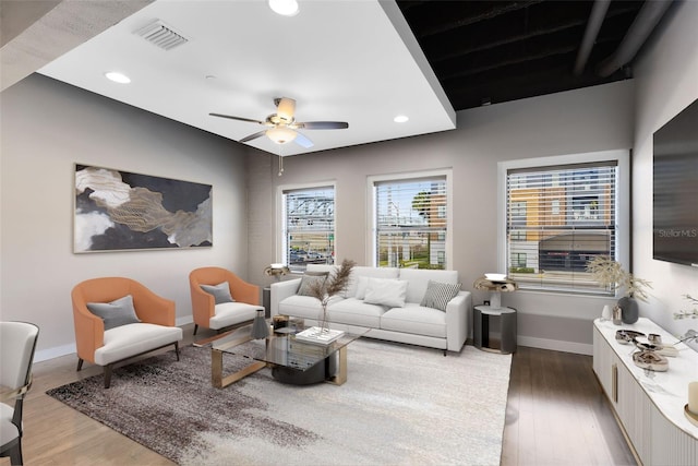 living room featuring ceiling fan and dark hardwood / wood-style floors